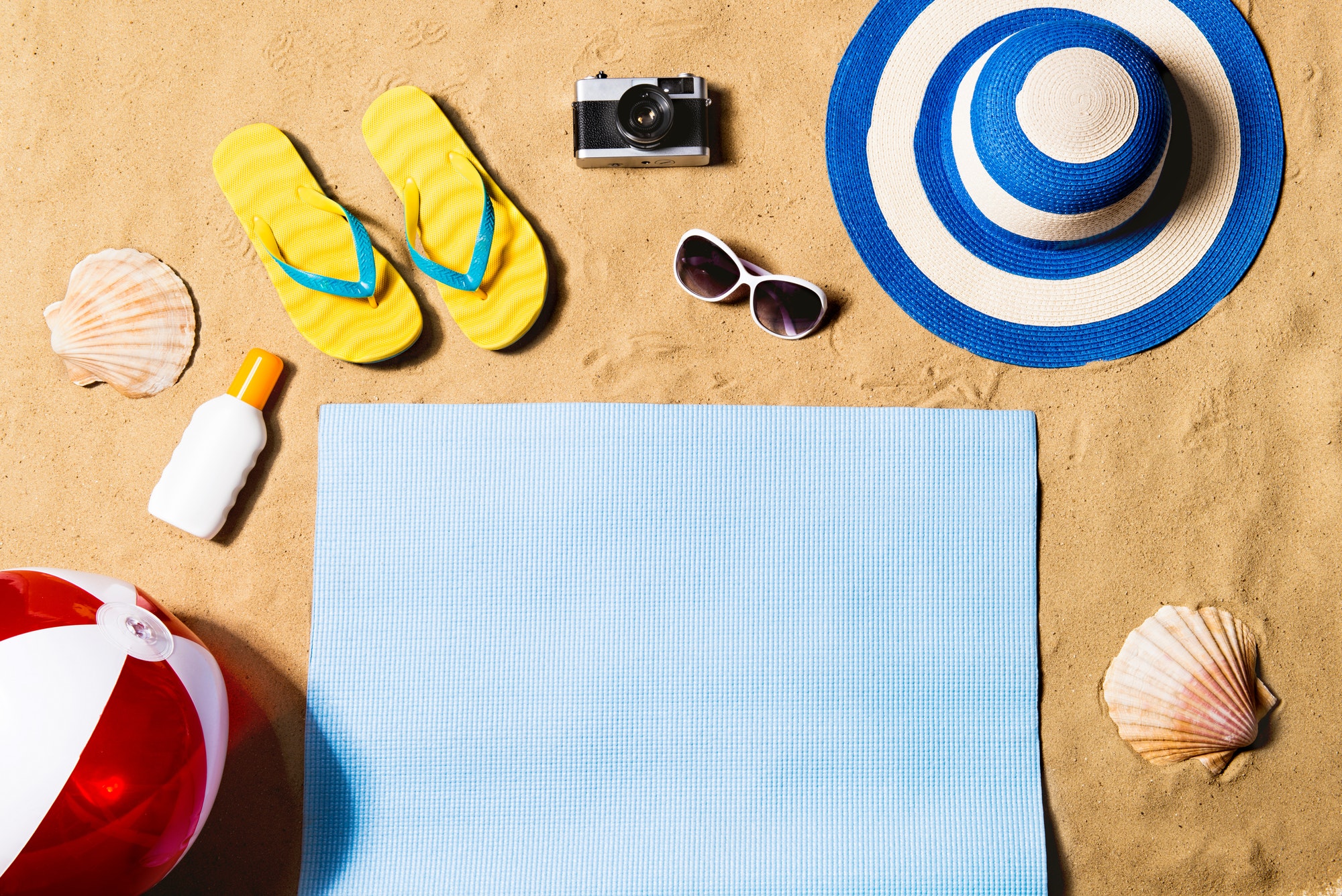 Summer vacation composition. Sandals, hat and beach ball.